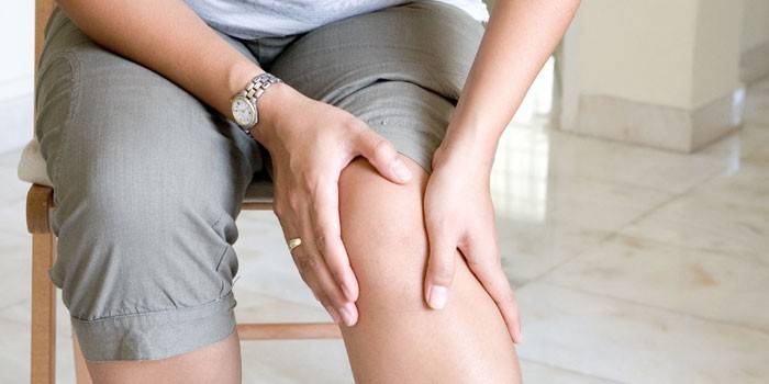 La mujer tiene dolor de rodilla.