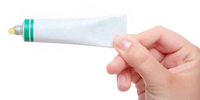 Tuba con ungüento en mano