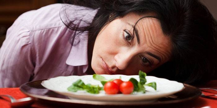 Menina olha para um prato de comida
