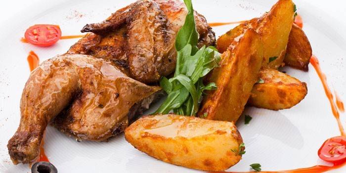 Medio pollo al tabaco al horno con papas en un plato