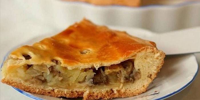 Un pedazo de pastel con champiñones y papas