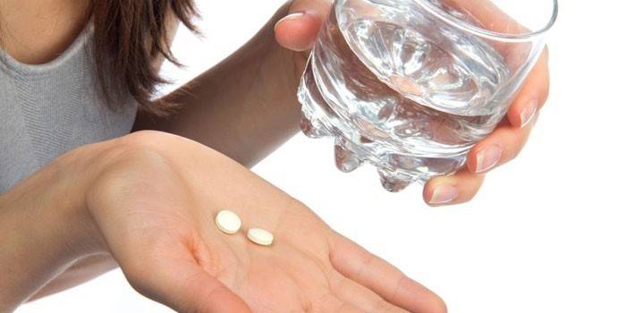 Pastillas y vaso de agua.