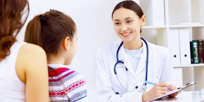 Mãe com filha na consulta do médico