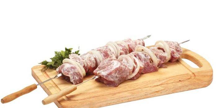 Pedaços de carne de porco em conserva com cebola no espeto