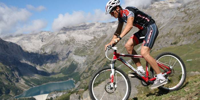 Um homem anda de bicicleta de montanha