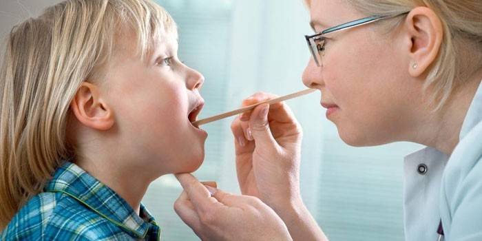 El médico examina la garganta de un niño.