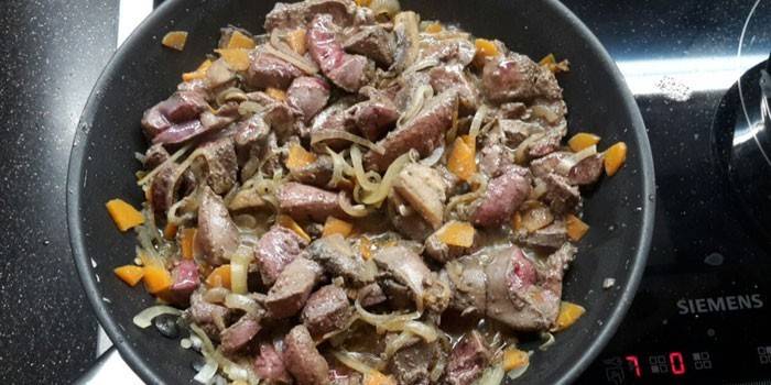 Carne con despojos y verduras en una sartén