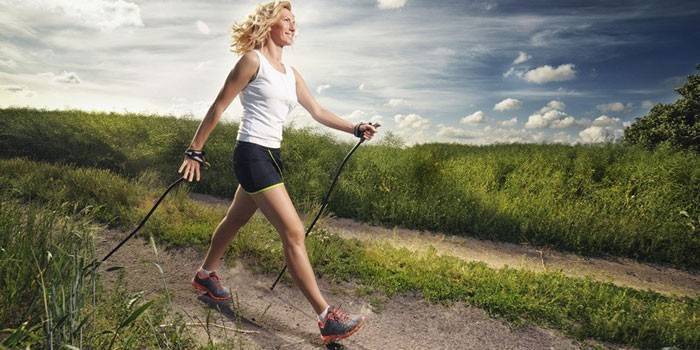 Dziewczyna uprawia nordic walking.
