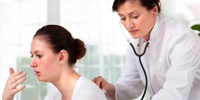 O médico ouve os pulmões do paciente com um estetoscópio.