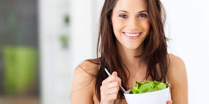 Niña sostiene un plato con ensalada