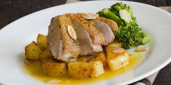 Peito de pato em fatias em um travesseiro de batata