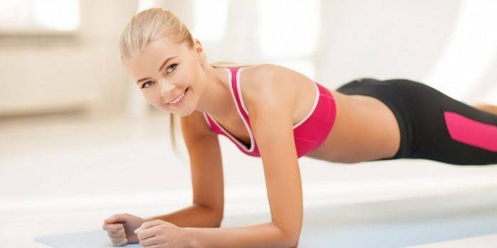 Menina realiza uma prancha de exercício