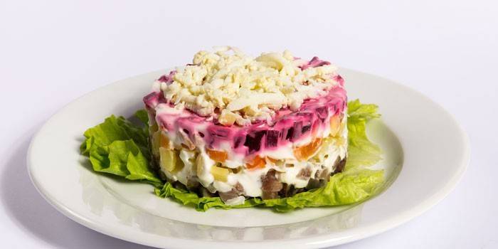 Arenque debajo de un abrigo de piel en un plato