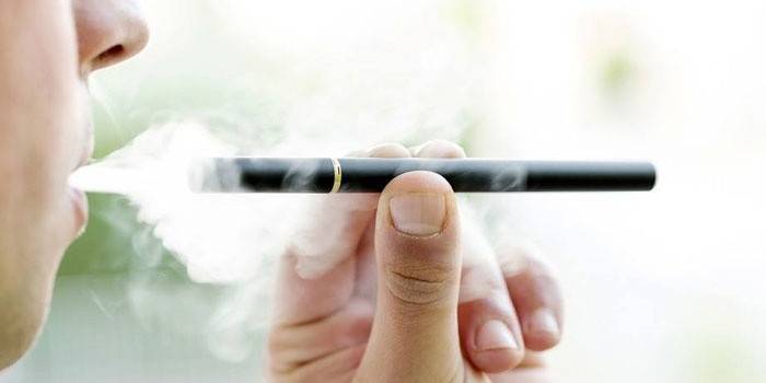 Um homem fuma um cigarro eletrônico