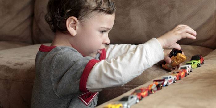 Niño jugando con coches de juguete