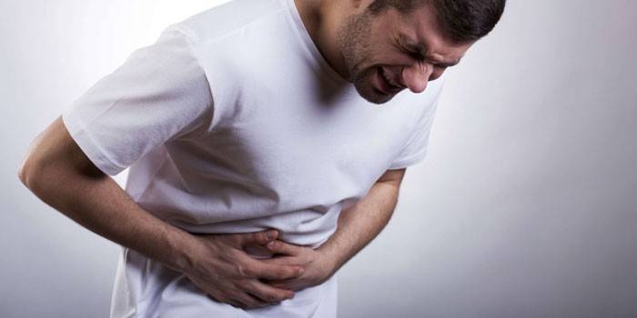Un hombre tiene dolor de estómago.