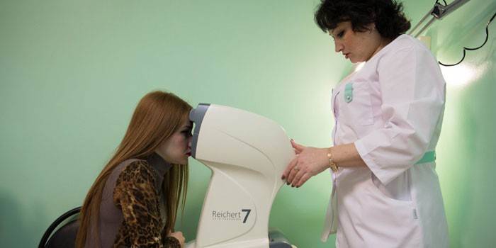 O médico mede a pressão do olho da menina
