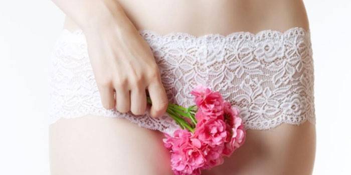 Chica sosteniendo una flor en el frente