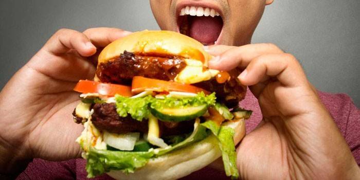 Hombre con una hamburguesa en sus manos