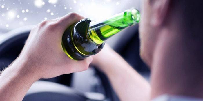 Hombre conduciendo una cerveza de una botella