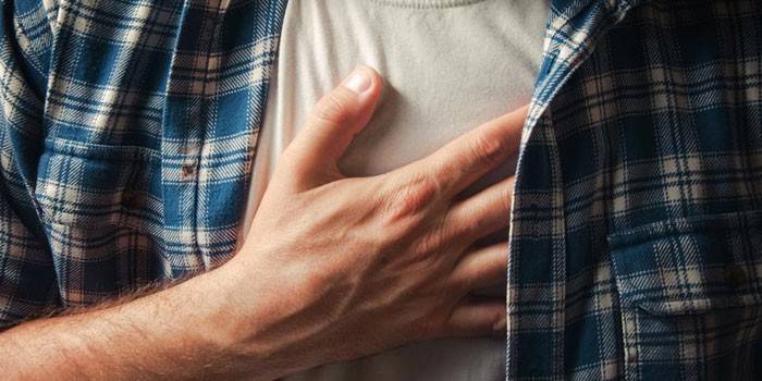 Un hombre sostiene su mano en el corazón.