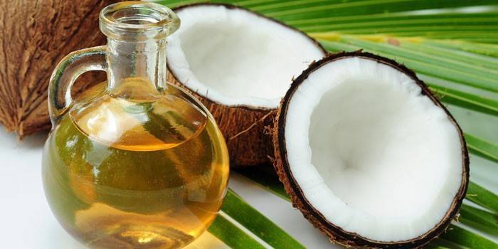 Aceite de coco en una jarra y coco