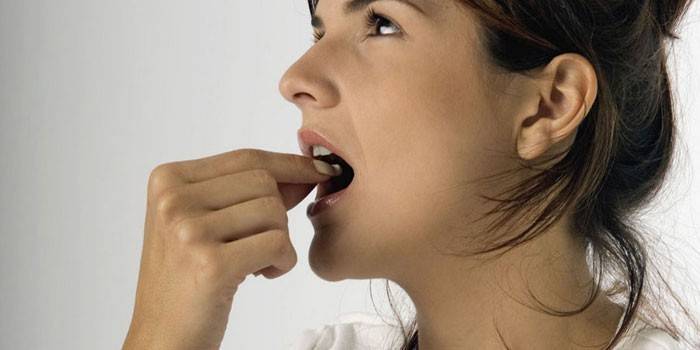 Chica toma una pastilla