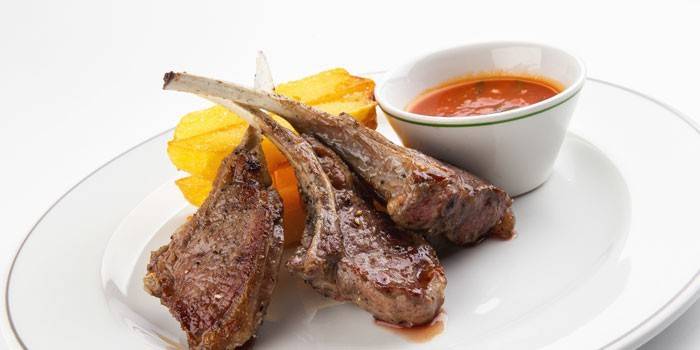 Costillas de cordero con papas fritas y salsa