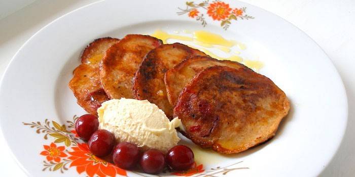 Panqueques dulces con helado y cereza en un plato