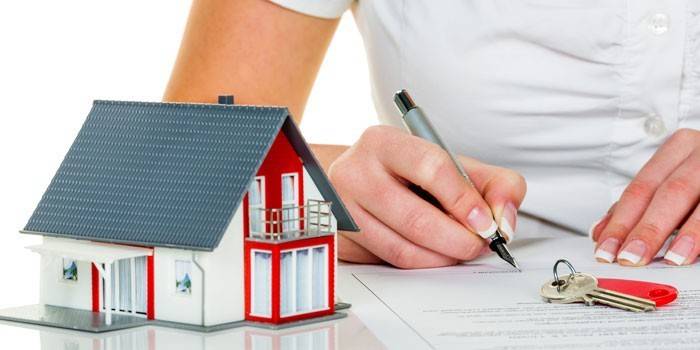 Chica firma papel, casa y llaves