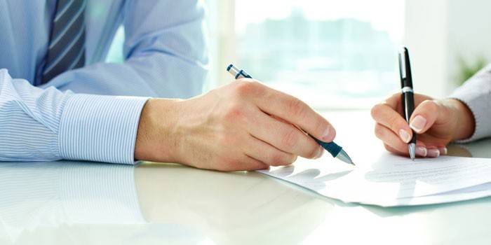 Hombre y mujer firman un documento