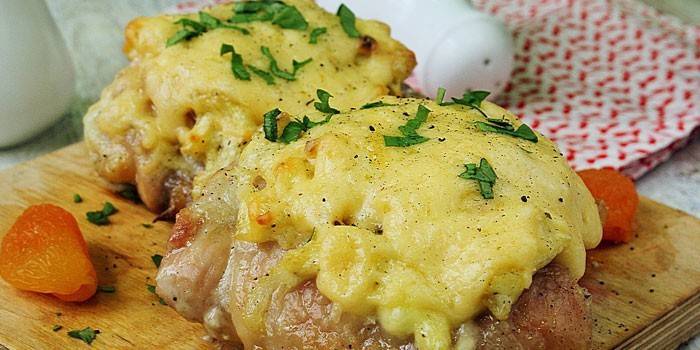 Muslos de pollo terminados bajo una tapa de queso