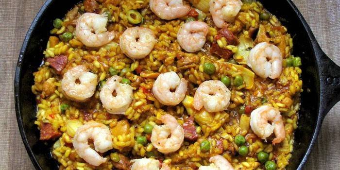 Paella com carne e camarão em uma panela