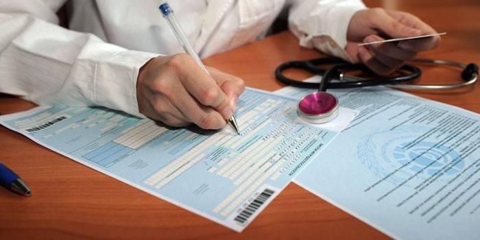 El médico llena una hoja de discapacidad.