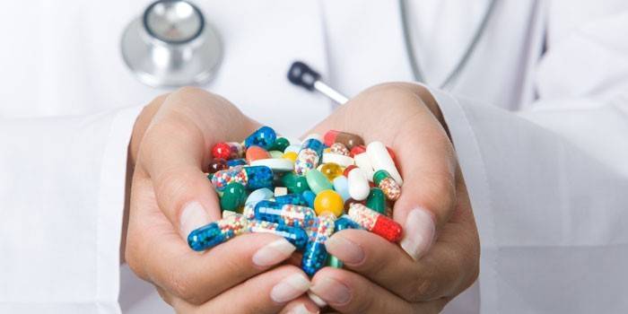 Comprimidos e cápsulas nas palmas das mãos de um médico
