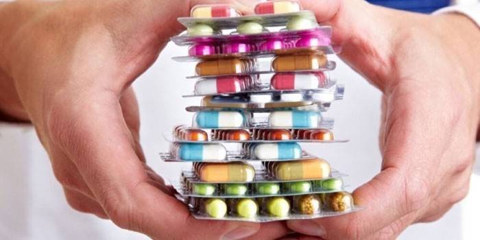 Pastillas y cápsulas en las manos.