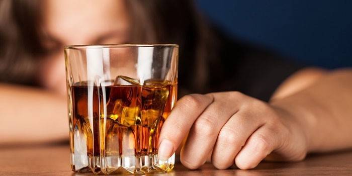 Kieliszek whisky w kobiecej dłoni