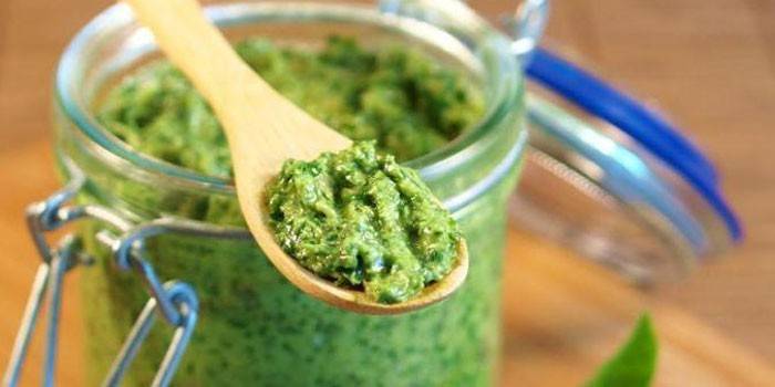 Pesto em uma jarra e uma colher de pau