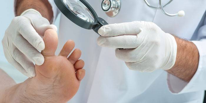 O médico examina a perna do paciente