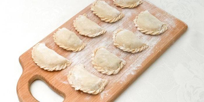 Bolinhos de massa em uma placa de corte antes de cozinhar
