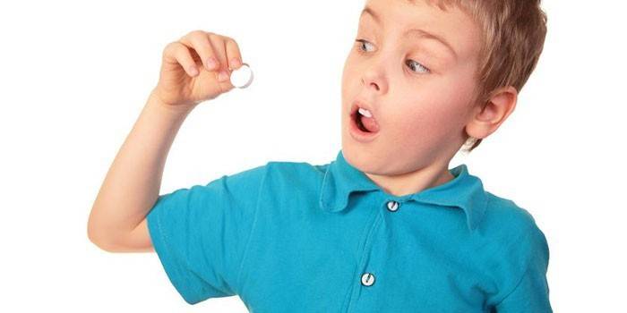 Niño con una pastilla en la mano