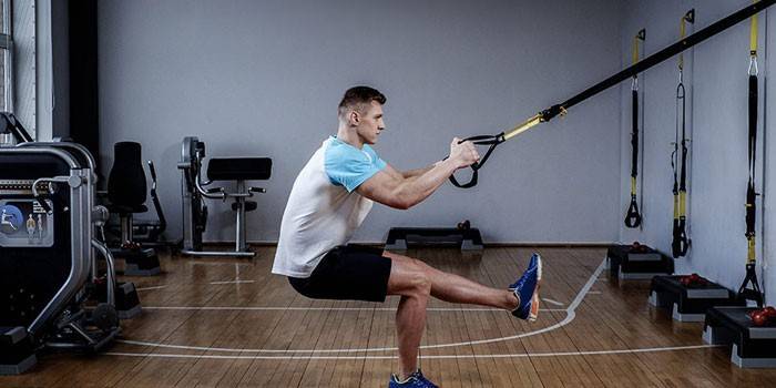 El hombre realiza ejercicio TRX para los músculos de las piernas