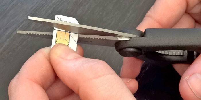 Um homem corta um cartão sim de acordo com o padrão com uma tesoura