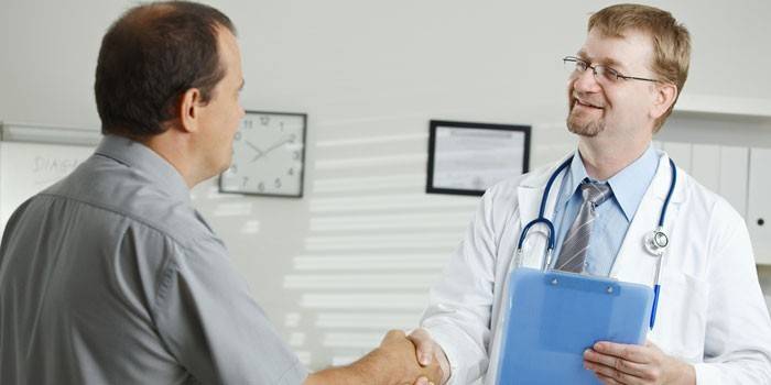 El hombre le da la mano a un médico