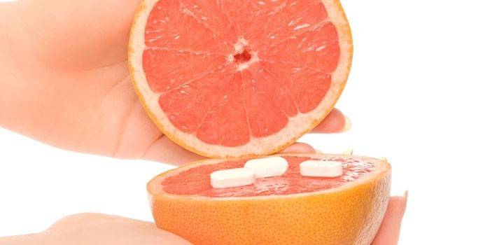 mitades de pomelo y pastillas