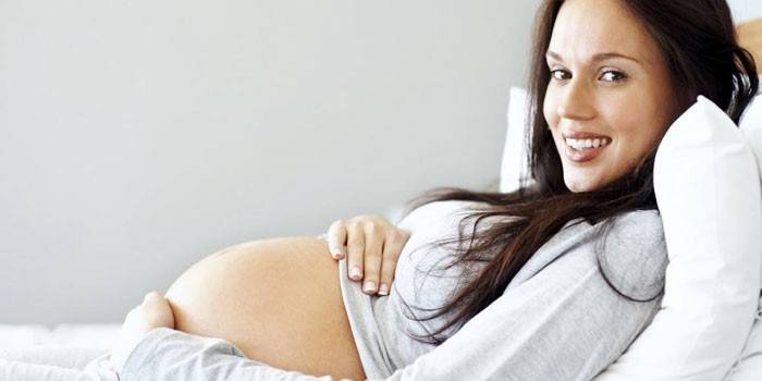 Niña embarazada yace en la cama