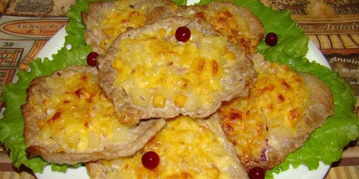Chuletas al horno con rodajas de piña debajo de una tapa de queso
