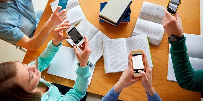 Alunos com livros e telefones.