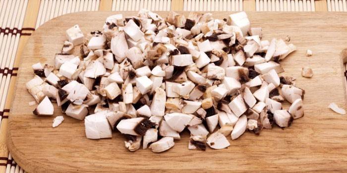 Pokrojone pieczarki na desce do krojenia
