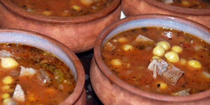 Sopa com grão de bico e cordeiro em panelas de barro